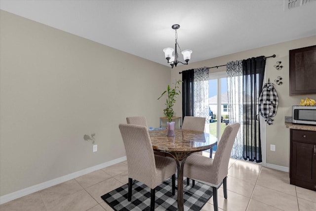 tiled dining room featuring an inviting chandelier