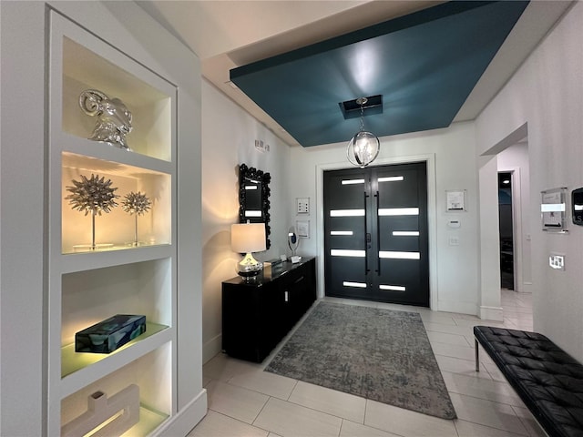 tiled entryway featuring an inviting chandelier