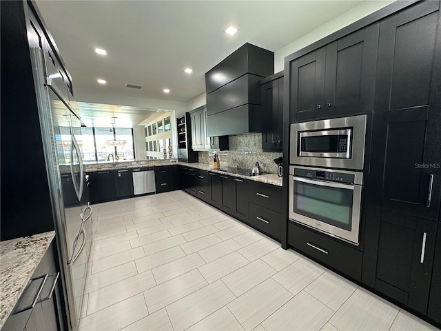 kitchen with custom range hood, appliances with stainless steel finishes, decorative light fixtures, and light stone countertops