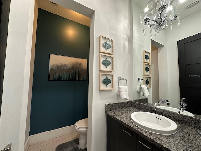 bathroom with vanity, tile patterned flooring, toilet, and an inviting chandelier