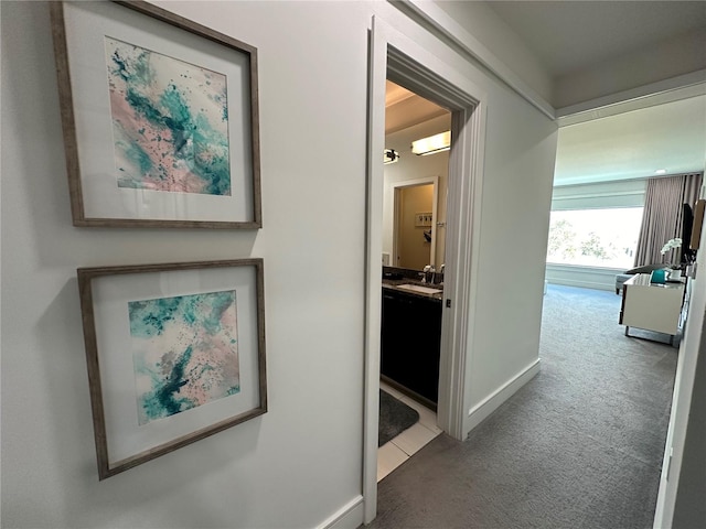 hall with sink and carpet