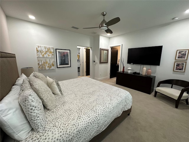 bedroom featuring a closet, a spacious closet, light colored carpet, and ceiling fan