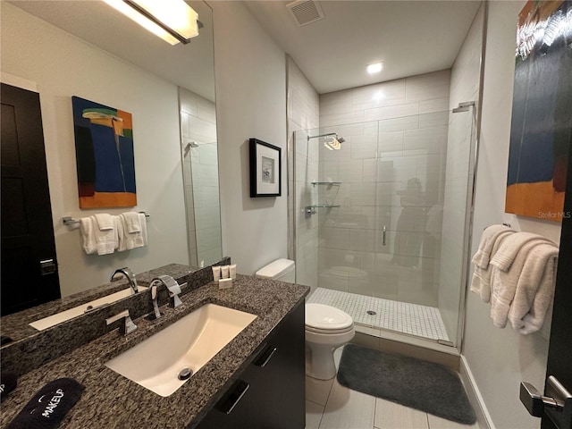 bathroom with tile patterned flooring, vanity, toilet, and a shower with door