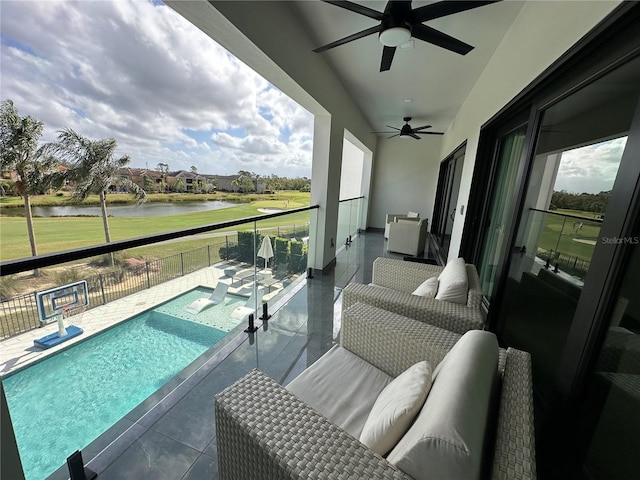 balcony with a water view, ceiling fan, a patio, and an outdoor hangout area