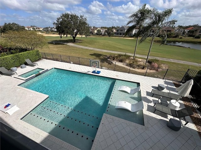 view of pool with a yard, a water view, and a patio area