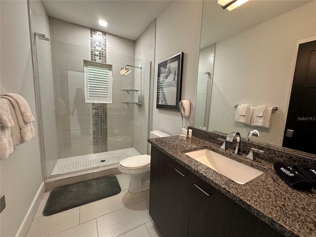 bathroom with toilet, vanity, tile patterned floors, and a shower with door