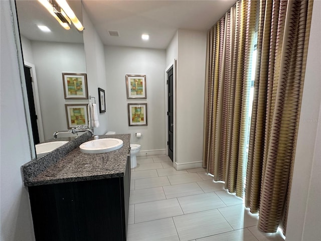 bathroom with tile patterned flooring, vanity, and toilet