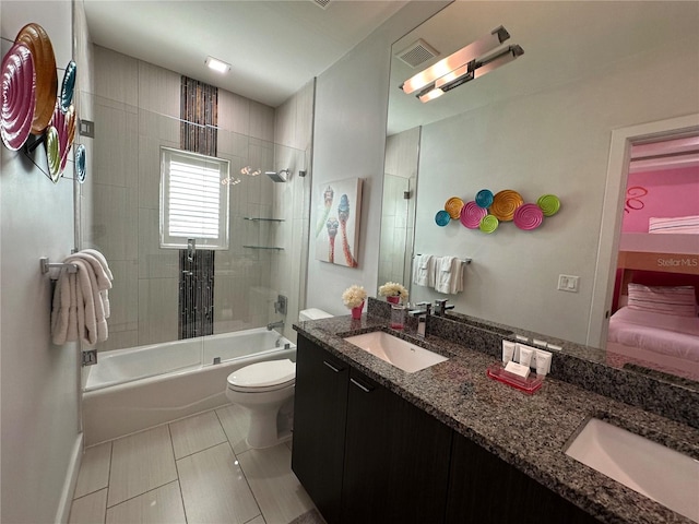 full bathroom with tiled shower / bath, tile patterned floors, toilet, and vanity