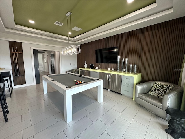 recreation room with pool table, a notable chandelier, wood walls, and a tray ceiling