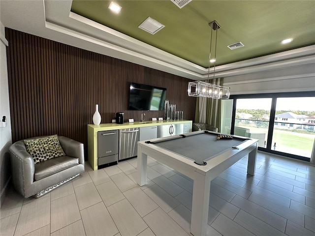 recreation room with wood walls, pool table, and a tray ceiling