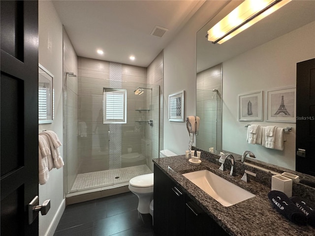 bathroom featuring toilet, an enclosed shower, vanity, and tile patterned floors