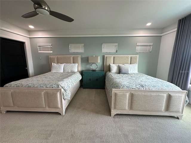 carpeted bedroom featuring a wall mounted AC and ceiling fan