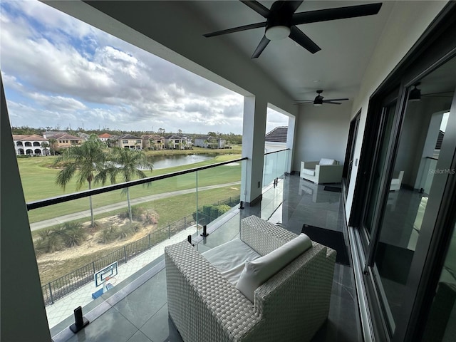 balcony with a water view, ceiling fan, an outdoor living space, and a patio area