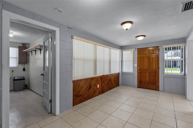 tiled entryway with tile walls and electric panel