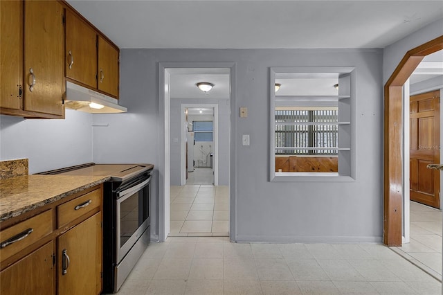 kitchen featuring light stone counters and stainless steel electric stove