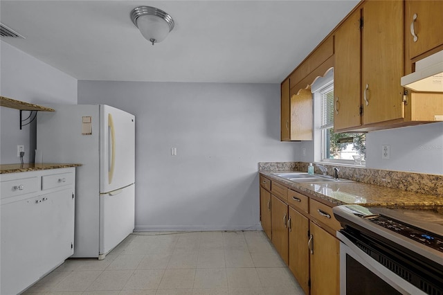 kitchen featuring sink, white refrigerator, and range