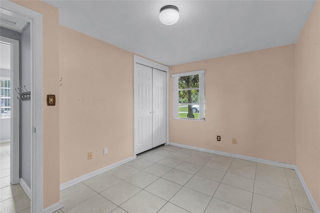 unfurnished bedroom with a closet and light tile patterned floors