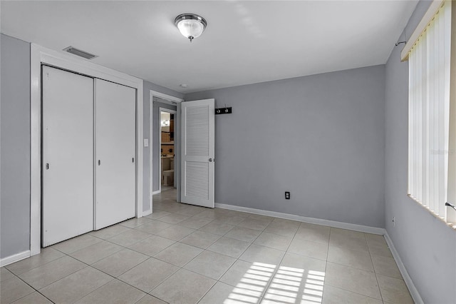 unfurnished bedroom with a closet and light tile patterned floors