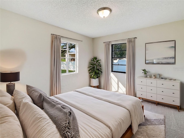 bedroom featuring a textured ceiling and carpet flooring