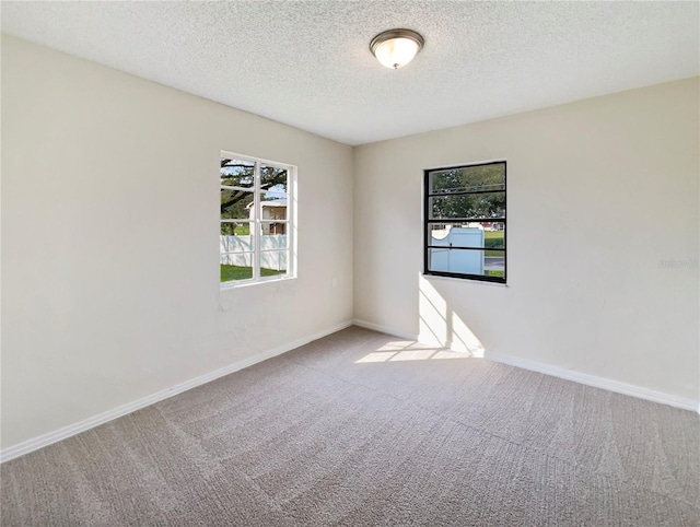 carpeted spare room with a textured ceiling