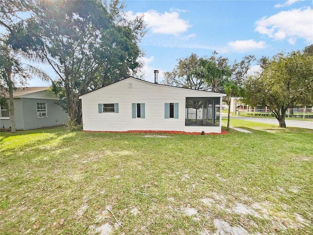 back of property featuring a yard and a sunroom