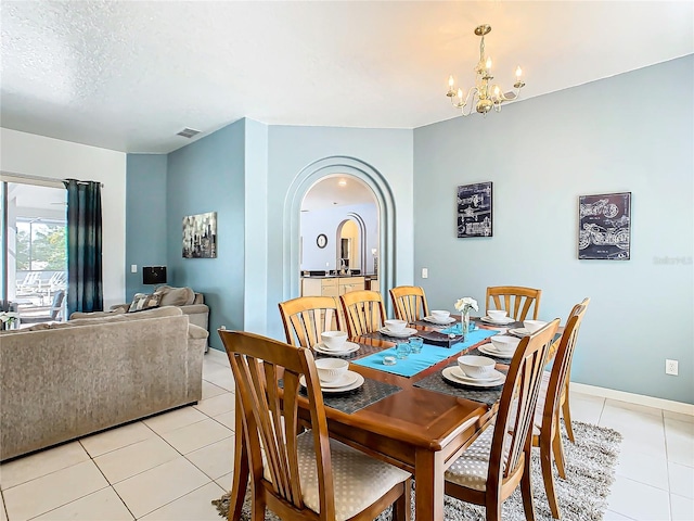 tiled dining room with an inviting chandelier, a textured ceiling, and sink