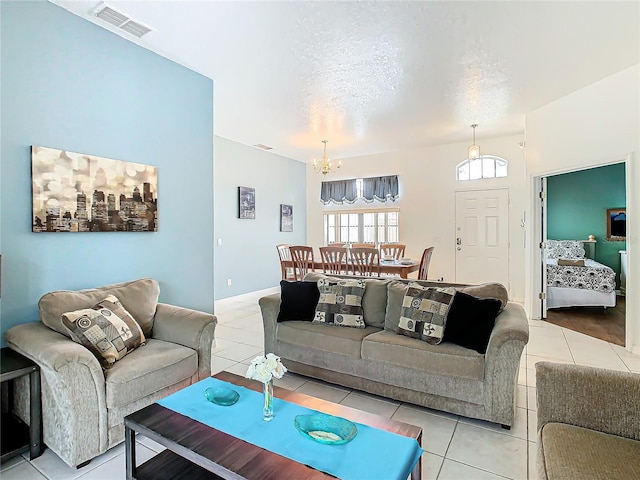 tiled living room with a notable chandelier and a textured ceiling