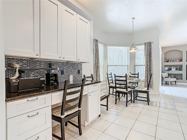 kitchen featuring decorative backsplash, pendant lighting, and white cabinets