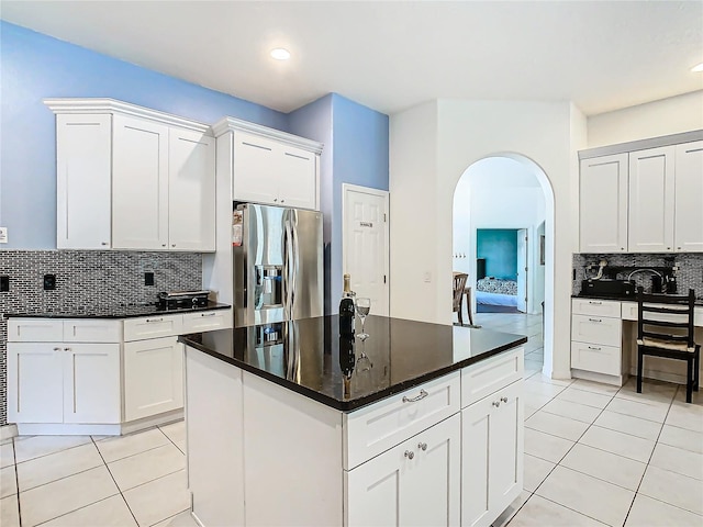 kitchen featuring white cabinetry, backsplash, and stainless steel fridge