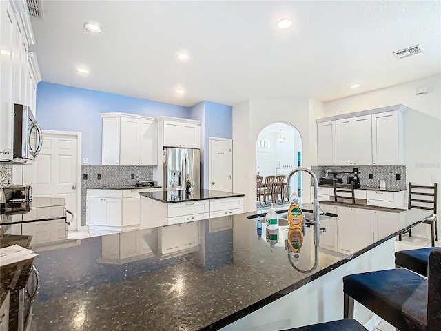 kitchen with backsplash, appliances with stainless steel finishes, sink, and white cabinets