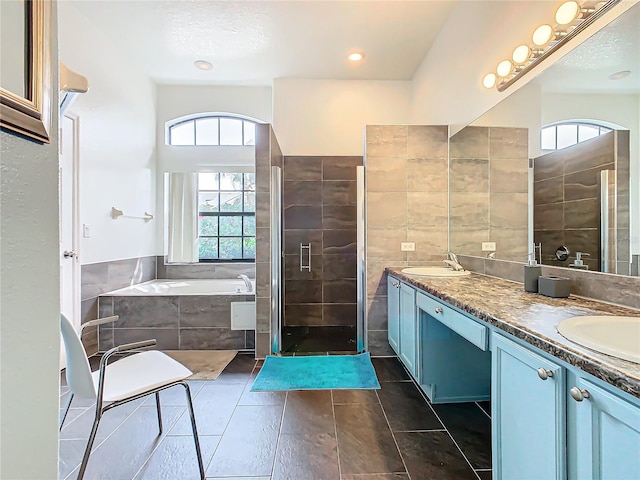 bathroom with tile walls, vanity, shower with separate bathtub, and tile patterned flooring