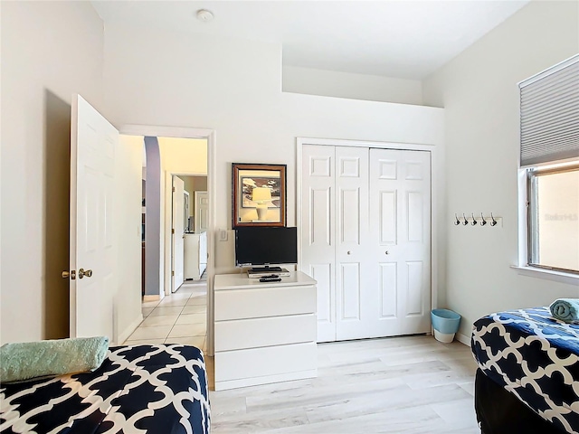 bedroom with light hardwood / wood-style floors and a closet