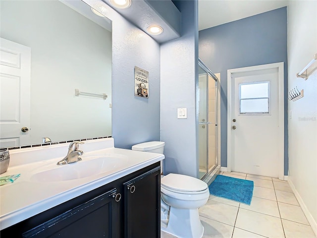 bathroom featuring vanity, toilet, a shower with shower door, and tile patterned flooring