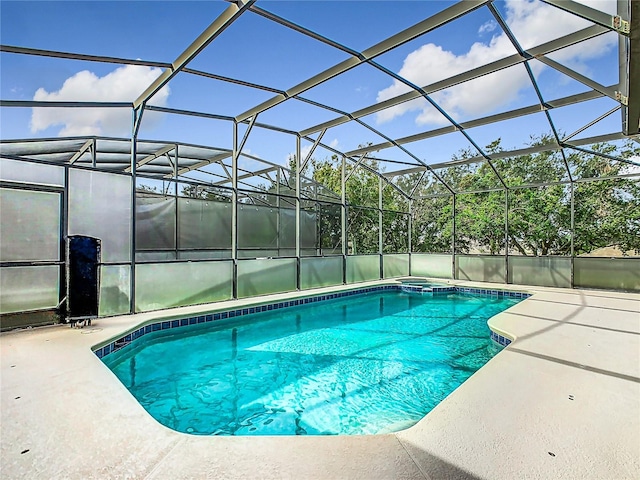 view of swimming pool with a patio area and glass enclosure