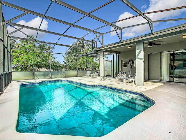 view of pool featuring a patio area, ceiling fan, and glass enclosure