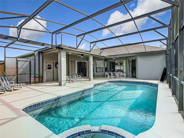 view of swimming pool featuring a patio, ceiling fan, and glass enclosure