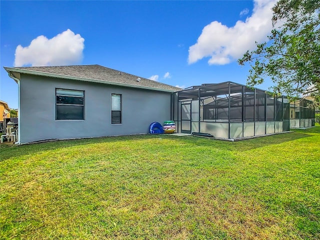 rear view of property with a pool, a lawn, and a lanai