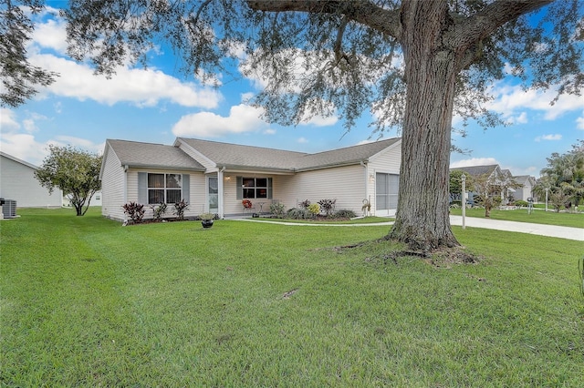 ranch-style house with cooling unit, a front yard, and a garage