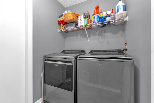 laundry area with washer and dryer and a textured ceiling