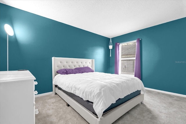 bedroom with a textured ceiling and light colored carpet