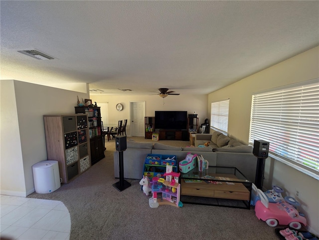 carpeted living room with a textured ceiling and ceiling fan