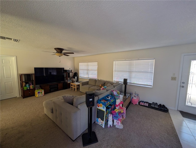 living room featuring carpet flooring, a textured ceiling, and ceiling fan