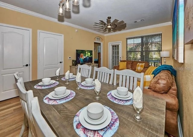 dining area featuring light hardwood / wood-style floors, ornamental molding, and ceiling fan