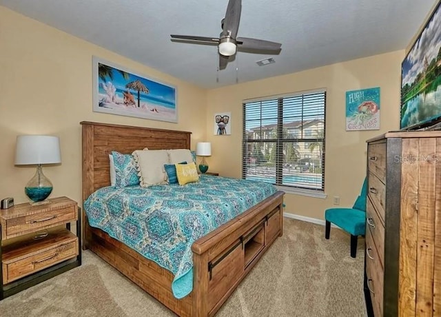 carpeted bedroom featuring baseboards, a ceiling fan, and visible vents