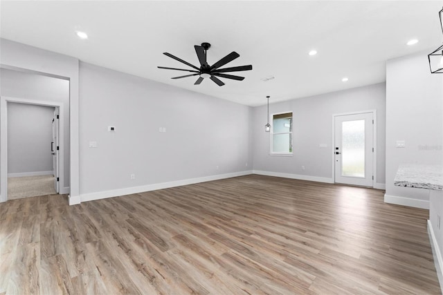 unfurnished living room with light wood-type flooring and ceiling fan