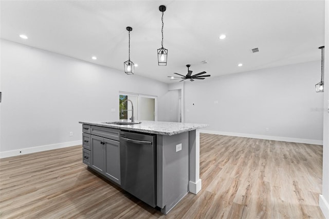 kitchen with dishwasher, hanging light fixtures, sink, and a center island with sink