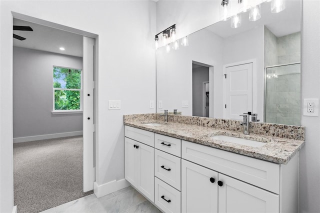 bathroom with vanity, a shower with shower door, and ceiling fan