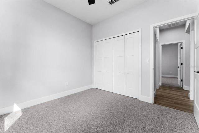 unfurnished bedroom with a closet, carpet flooring, and ceiling fan