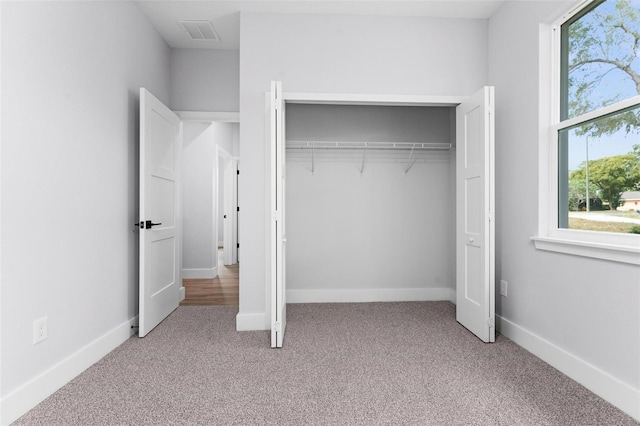 unfurnished bedroom with light carpet and a closet