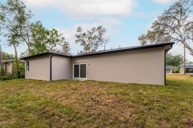 rear view of property featuring a yard